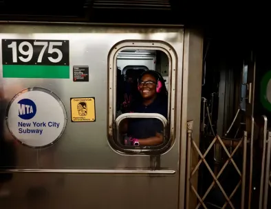 train operator smiling through subway window