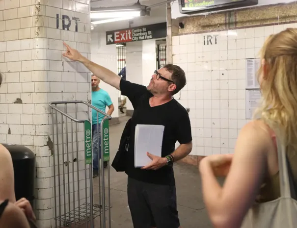 guide pointing at IRT sign in NYC subway