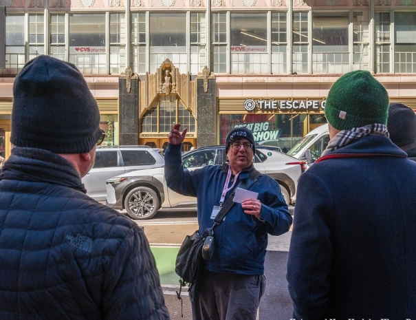 Tour leader with a group in front of the Brill Building in NYC
