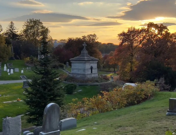 A wide view of a mausoleum and graves at the Green-Wood Cemetery