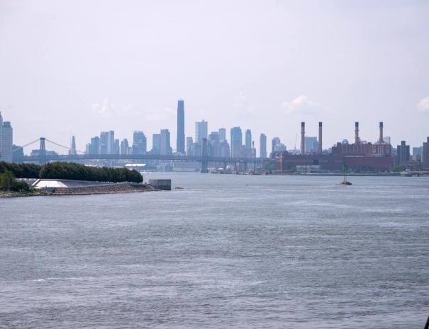 View south down the East River toward the Williamsburg Bridge, with the Brooklyn skyline and the four smokestacks of the Con Edison East River Generating Station.