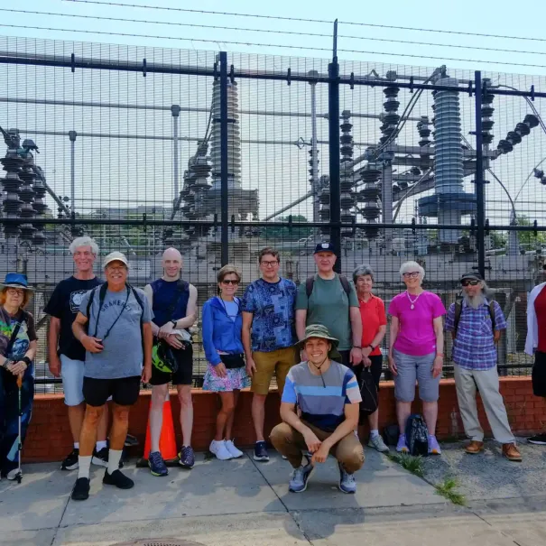 A tour group poses outside a power plant in Inwood