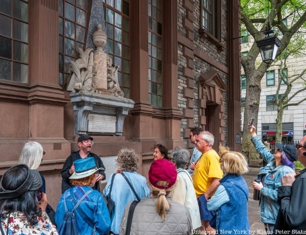 A group of Untapped New York walking tour guests gathered outside an St. Paul's Chapel in lower Manhattan, with the guide pointing out architectural and historical details
