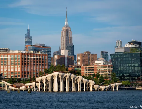 Little Island's tulip-shaped concrete pots on the Hudson River with the Empire State Building behind