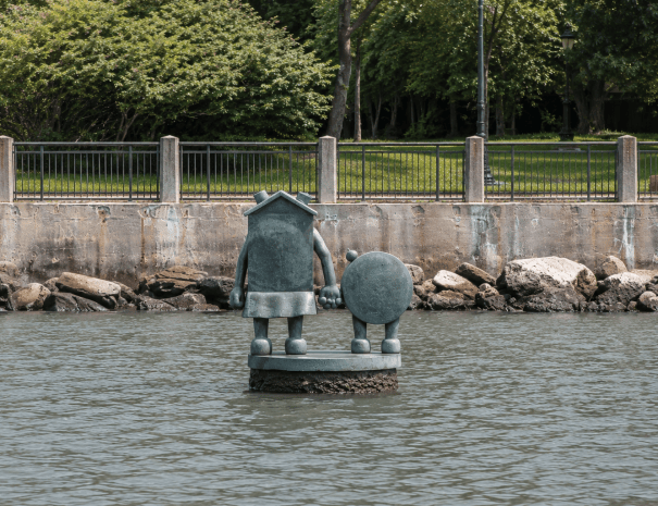 Tom Otterness's The Marriage of Money and Real Estate rising from the East River off Roosevelt Island