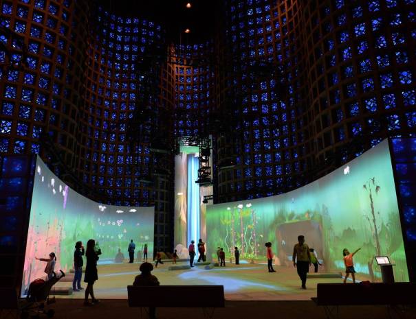 Inside the New York Hall of Science Great Hall, cobalt blue glass panels glow above children exploring an immersive projection exhibit