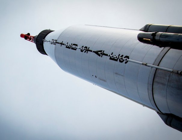 Looking up at an Atlas rocket topped with a Mercury capsule and red escape tower in Rocket Park at the New York Hall of Science